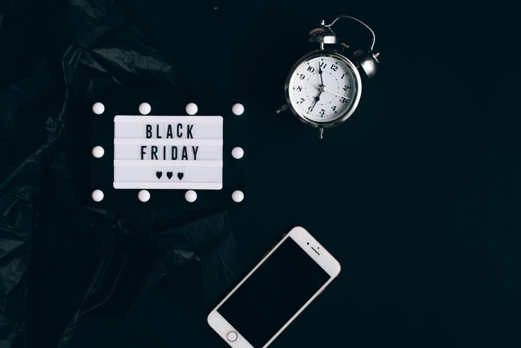 Clock, Black Friday Sign & Smartphone On A Black Background